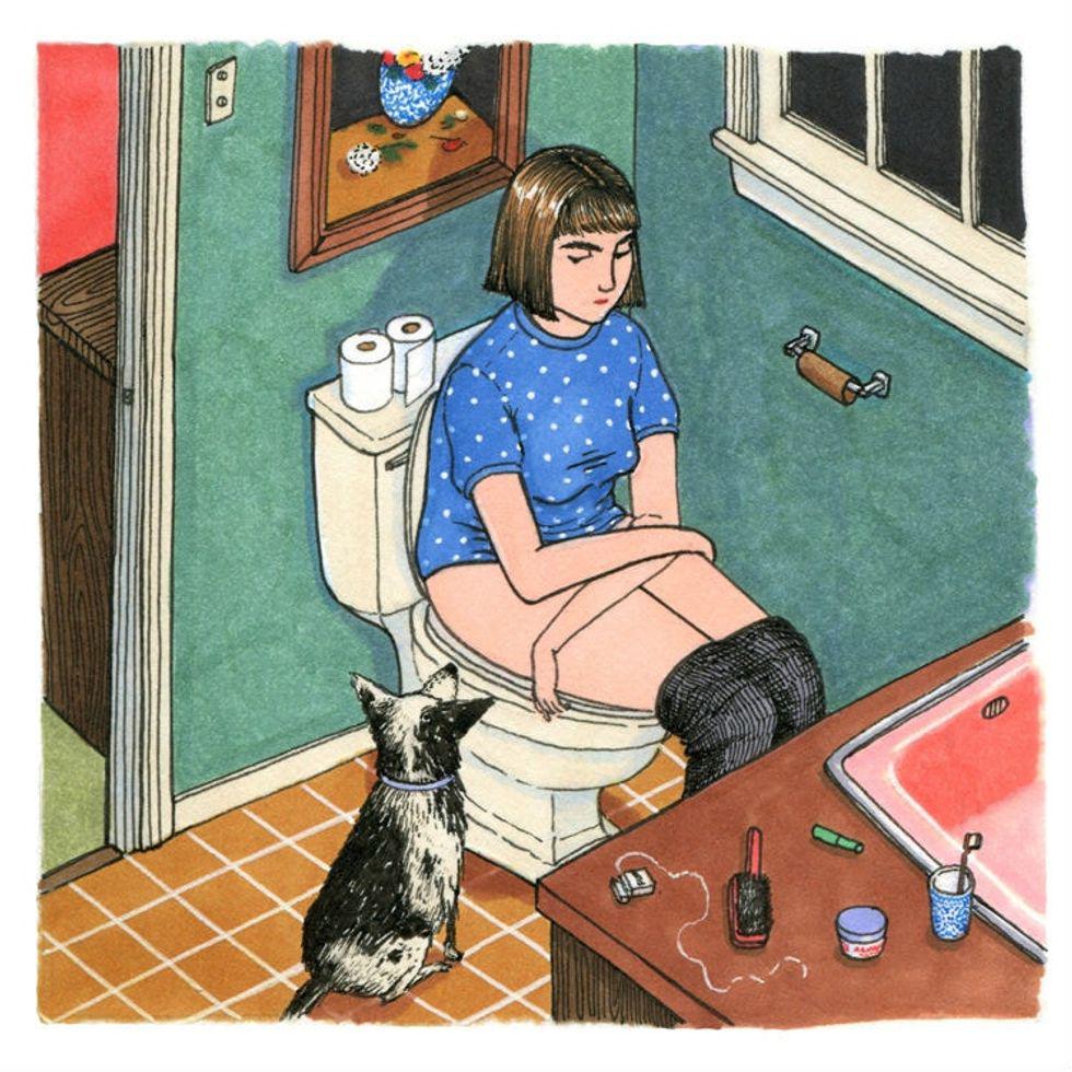 woman sits on the toilet with her dog beside her