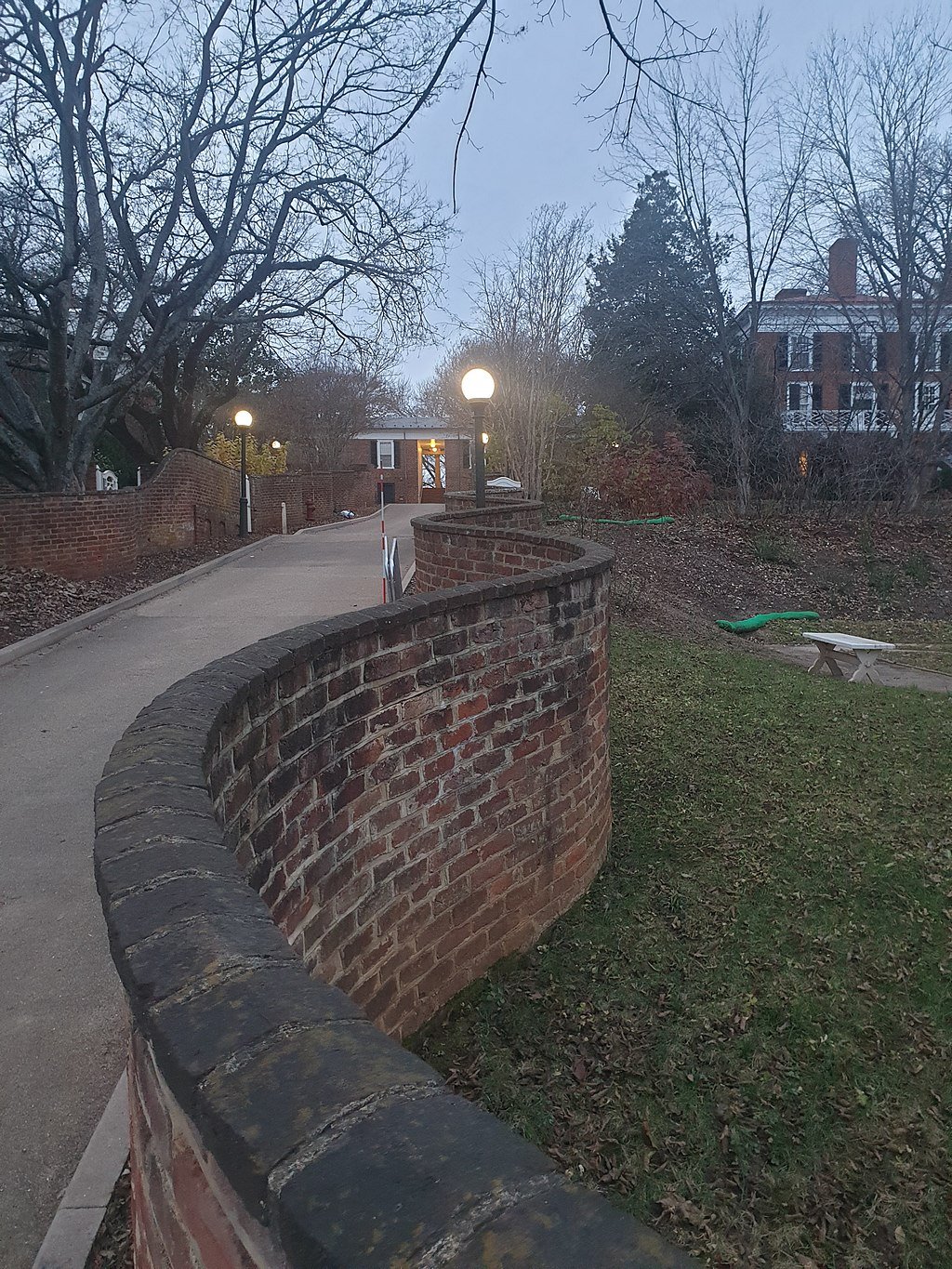 wavy brick wall separating a grassy area and a driveway