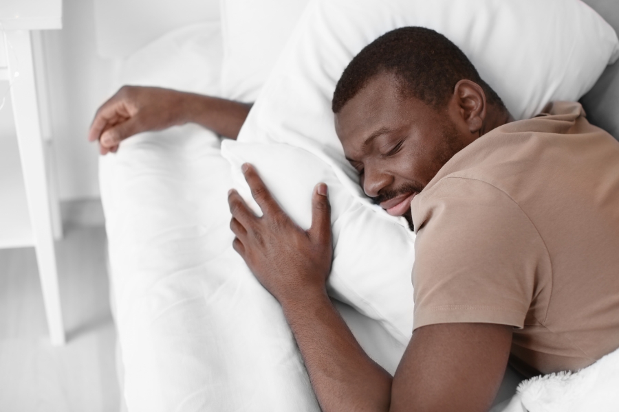 A man sleeps contentedly in a bed