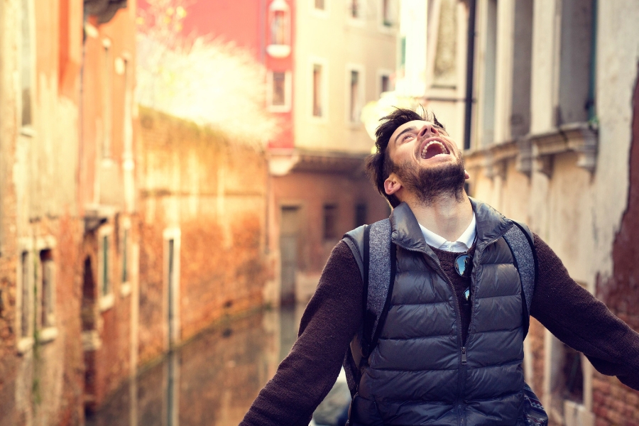 A man looks up at the sky with a big smile on his face