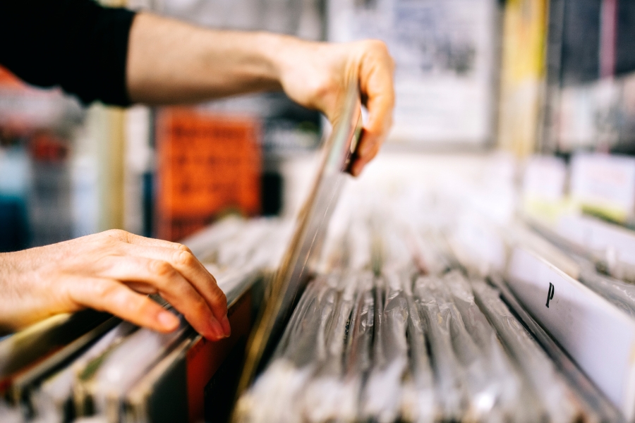 A person pulls a record out of a collection at a music shop