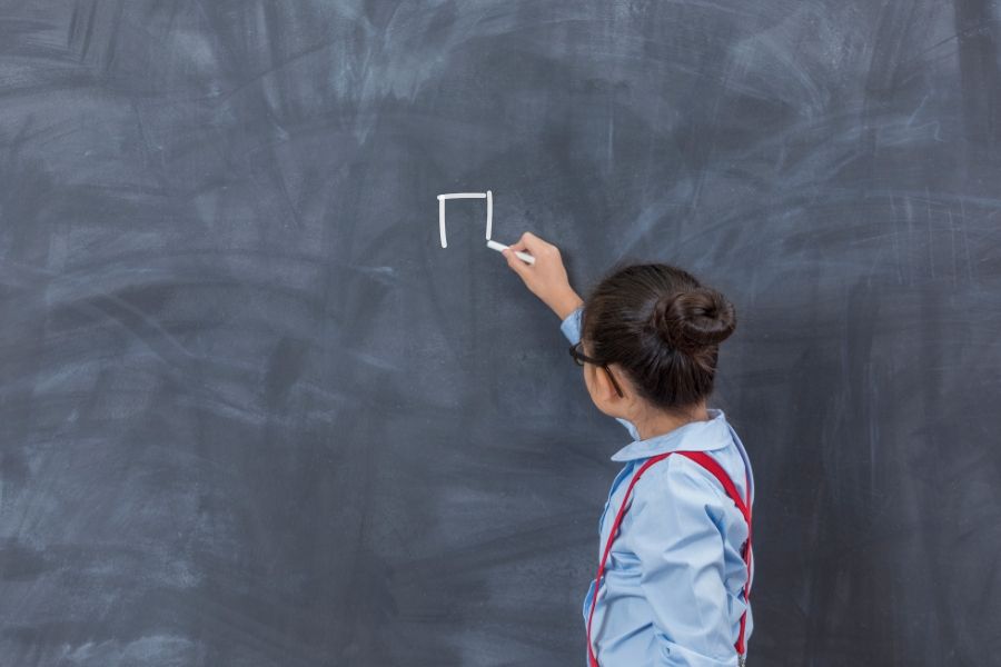 Student drawing a square on a chalkboard