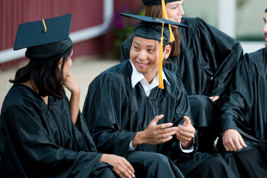 Two graduates talking to one another at graduation