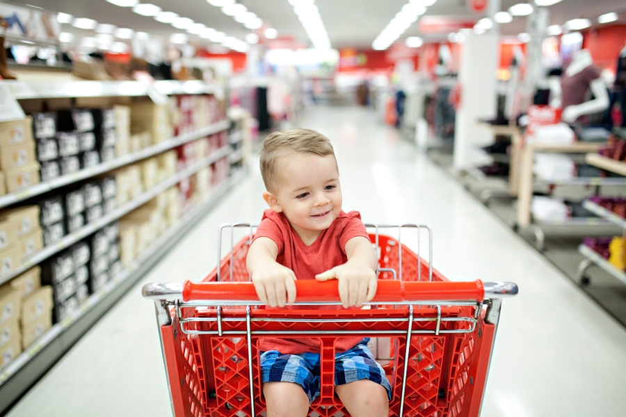 A preschooler sits in a grocery cart at Target