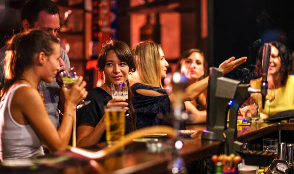 Four women sitting at a bar