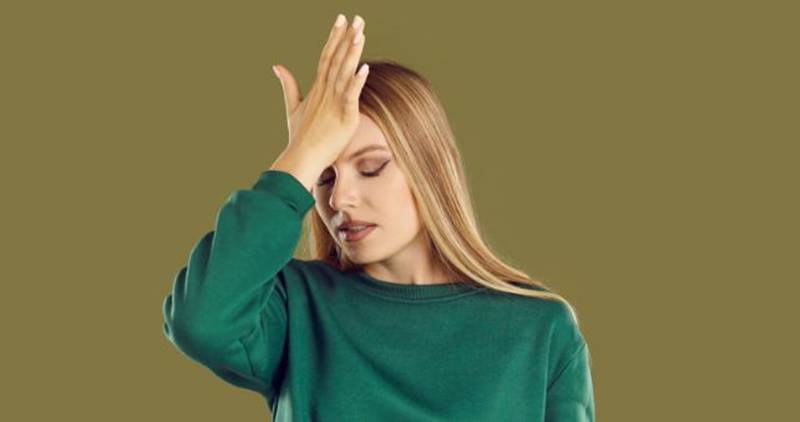 woman slaps forehead, upset woman, embarrassed woman, woman green sweatshirt, facepalm
