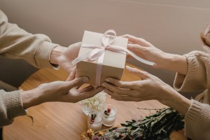 An older woman hands a younger woman a gift
