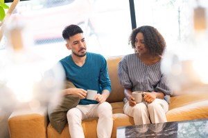 Two people sitting side by side on a couch having an awkward moment