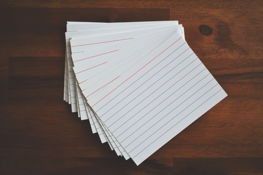 A pile of index cards sits on a table