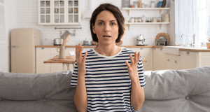 talking to seld, woman talking, woman on couch, brown hair woman, striped shirt