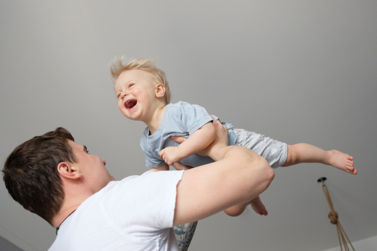 Dad expertly, and with comedic flair, demonstrates how to safely roughhouse with a baby