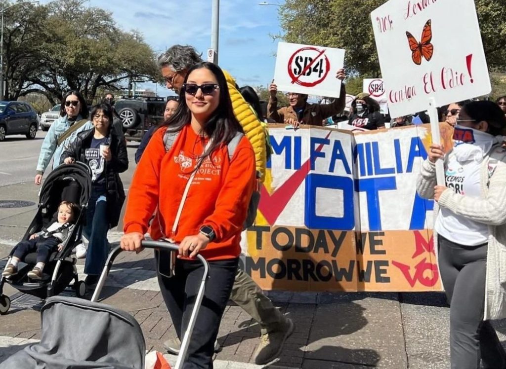 Sarah Chen pushing son Mills at a protest against SB 4 in early 2024