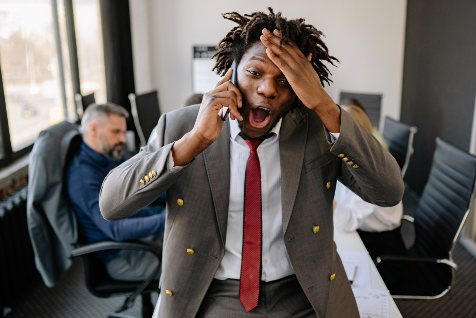 man at work, man on phone, emotional man, man grabbing forehead, man in suit