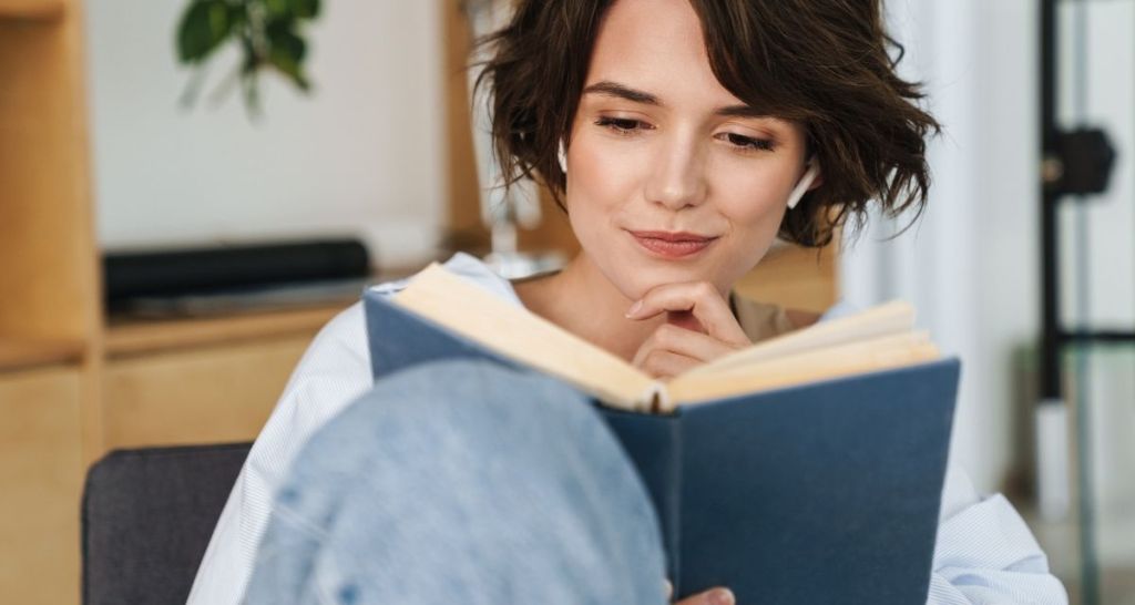 woman reading, listening to music, cozy home