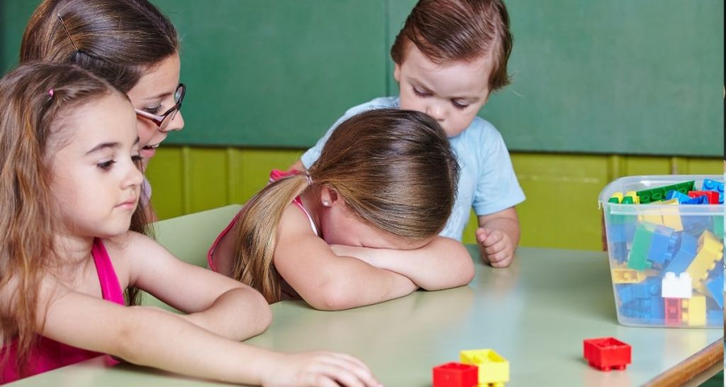 A girl crying at her table.