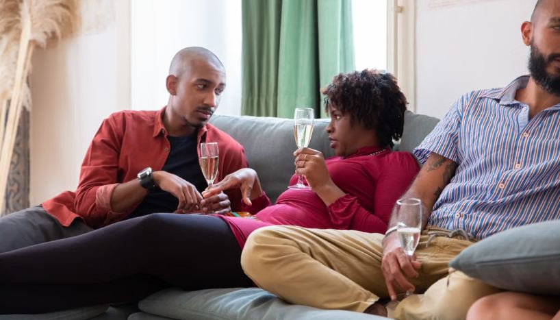 man and woman, couch, wine, party, conversation. 