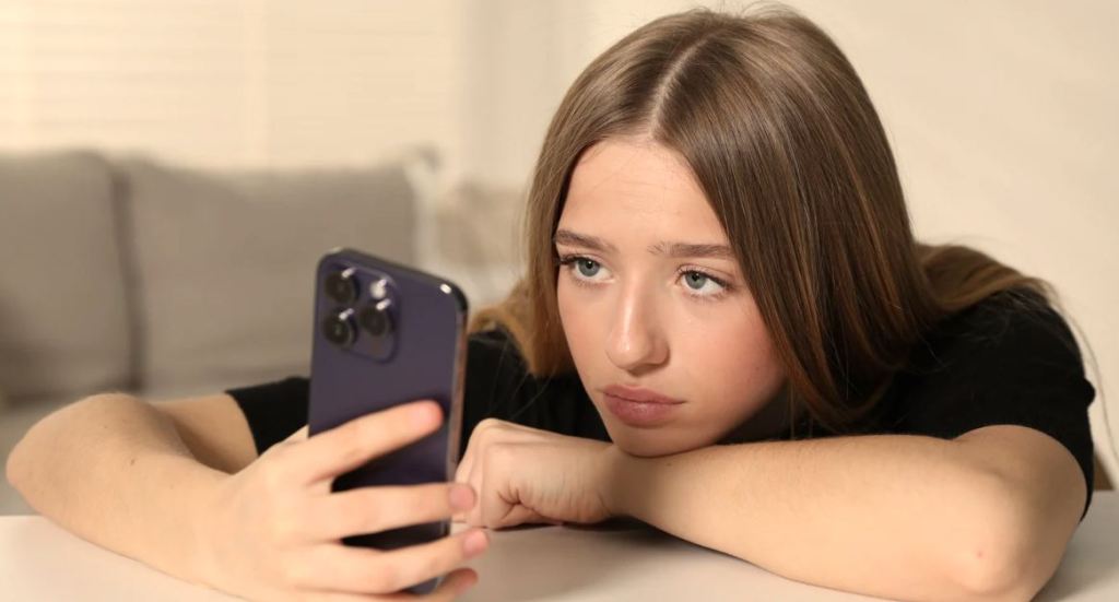 depressed teen, teenage girl, staring at phone