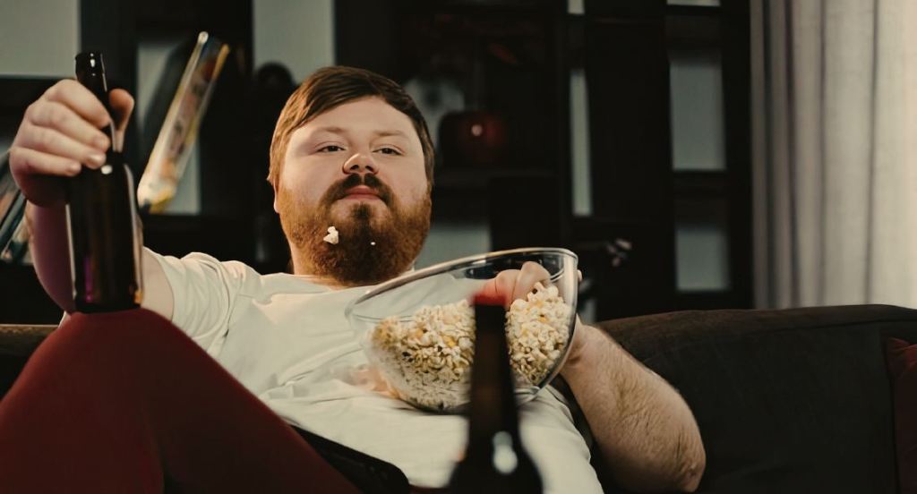 man on couch, man drinking beer, man with beard